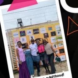 Attendees posing at the Operation Unadulting mural wall